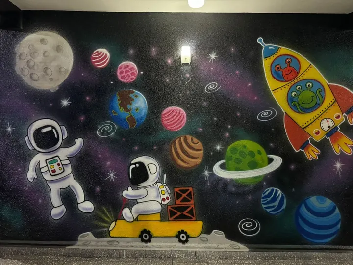Mural con astronautas, cohete, planetas y galaxias de Brincoliga