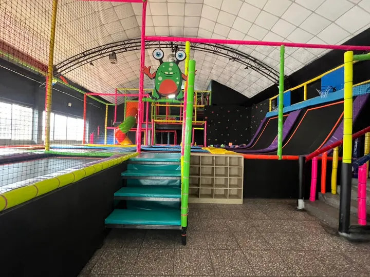 Acceso con escalones, camas elásticas y estructura multicolor del salón